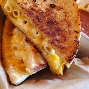 a grilled cheese sandwich with a side of tomato sauce