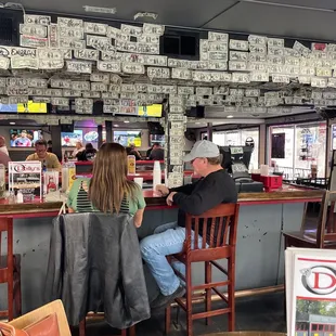 a man and woman sitting at a bar
