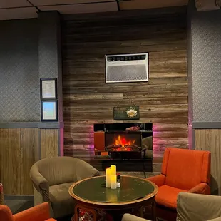 ows a fireplace and chairs