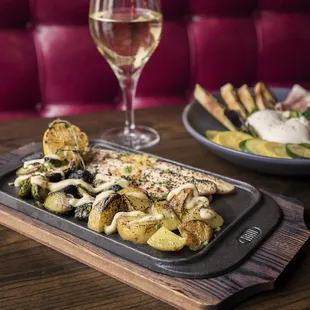 CAST IRON TROUT Topped with preserved lemon and herbs and served with confit brussels sprouts, Yukon potatoes and lemon aioli.