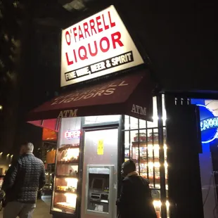 people walking in front of a liquor shop