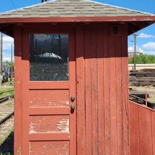 a red outhouse with a door