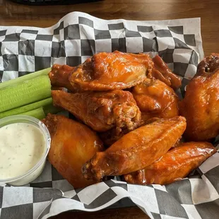 a basket of chicken wings and celery
