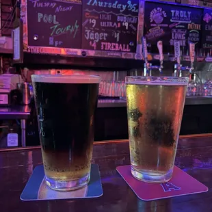 two glasses of beer on a bar