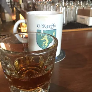 a glass of whiskey and a mug