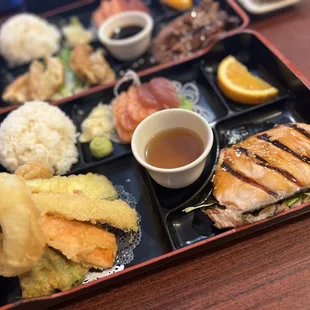 3 Item - Bento Box - Salmon - Tempura - Sashimi Served with rice and a slice of an orange