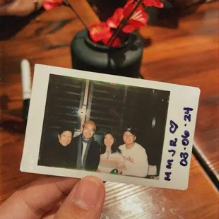 The server takes Polaroids of everyone.