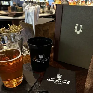 a glass of beer and a menu