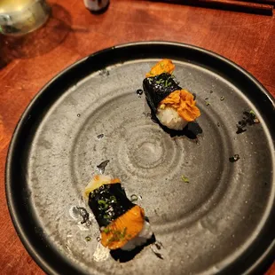 a plate of sushi on a wooden table