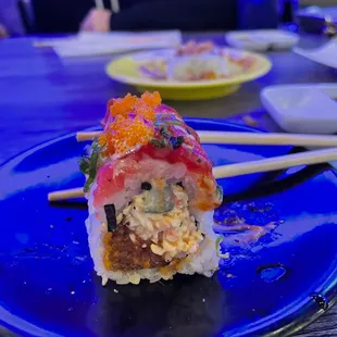 a plate of sushi with chopsticks