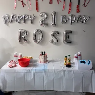 a birthday party table with balloons and confetti