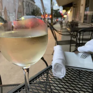 a glass of wine on a table outside