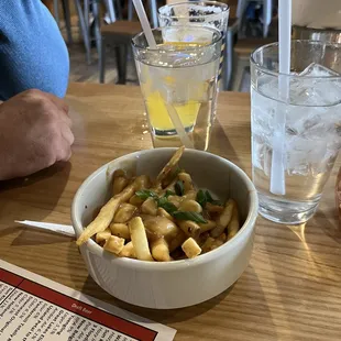 a bowl of french fries and a glass of water