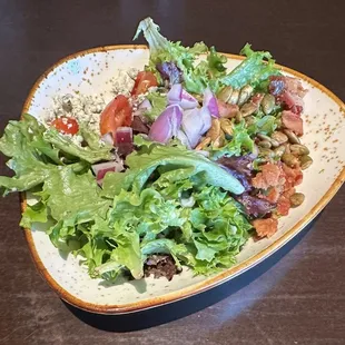 CHOPPED SALAD mixed greens, bacon, pepitas, tomato medley, red onion, blue cheese dust, creamy balsamic onion dressing