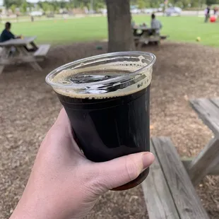 a hand holding a cup of beer