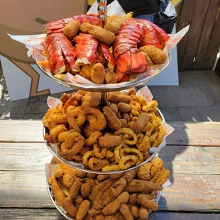 Seafood tower includes: Brown sugar hush puppies, fries, fish, scallops, shrimp AND calamari