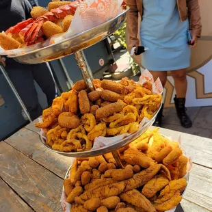 Seafood tower includes: Brown sugar hush puppies, fries, fish, scallops, shrimp AND calamari