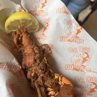 a fried lobster with a lemon wedge