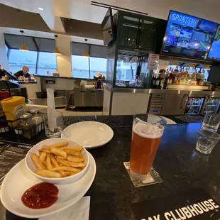 a table with a bowl of fries and a glass of beer
