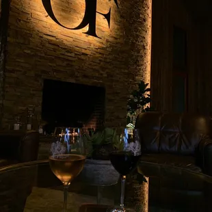 a glass of wine in front of a fireplace