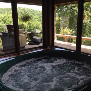 Heated indoor spa tub with panoramic view of grounds