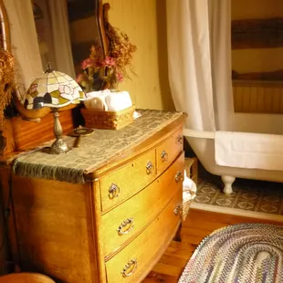 Antique claw-foot tub with shower and pedestal sink.