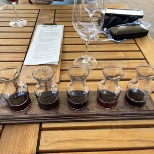 a flight of wine glasses on a wooden table