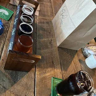 a table with beer glasses and a paper bag