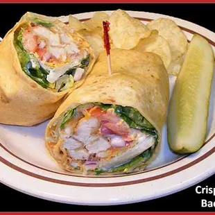 a chicken bacon wrap with chips and a pickle