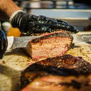 a man cutting meat on a cutting board