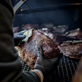 a man cooking steaks on a grill
