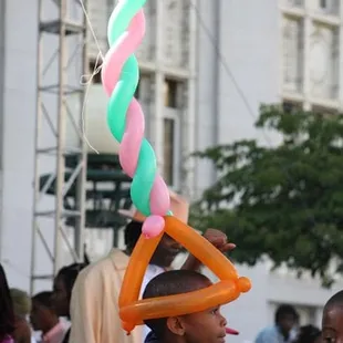 a boy with a balloon hat on his head