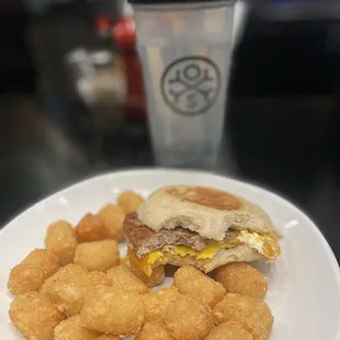 Eggs sausage cheese breakfast sandwich with tots