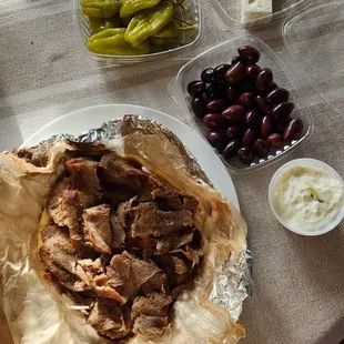 Gyro sandwich with side of feta, olives and pepperoncini