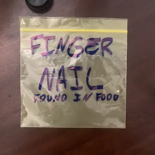 Fingernail above the D in Food in baggie