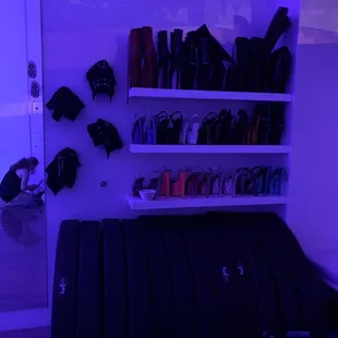 Shelves of high high HIGH heels and boots. Towels hang from walls to wipe down poles with spray water bottles.