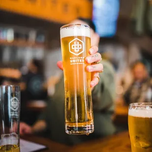 a person holding a pint of beer