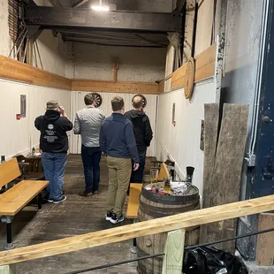 a group of people standing around a barrel