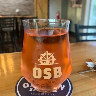 a glass of rose wine on a coaster