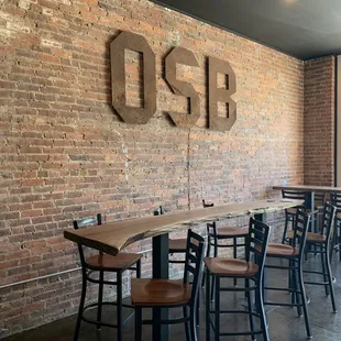 tables and chairs in front of a brick wall