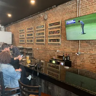 people sitting at bar watching television