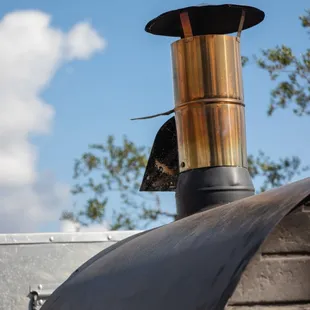 a copper chimney with a bird perched on it