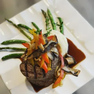 a steak with mushrooms, asparagus, and mashed potatoes