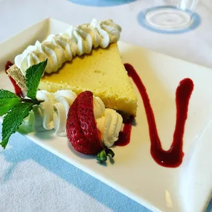 a slice of cheesecake with whipped cream and strawberries