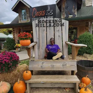  a woman sitting in a chair with pumpkins