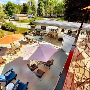  a view of a patio area with tables, chairs and umbrellas