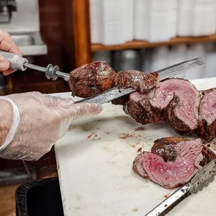 a chef slicing a piece of meat