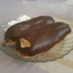 a chocolate covered donut on a glass plate