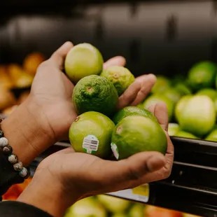 a person holding green apples