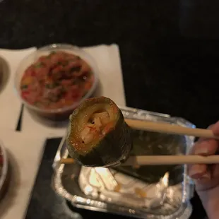 a person holding chopsticks over a plate of food